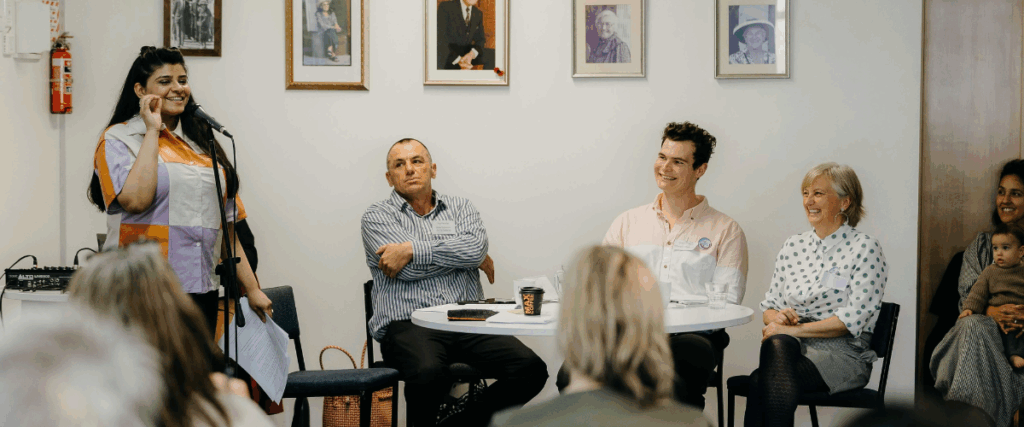 an image of someone speaking at the hui with people looking at them and smiling