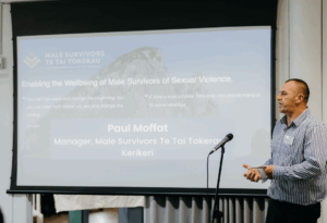 an image of Paul Moffat from the Male Survivors Te Tai Tokerau talking to a large group of people at the hui