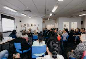 an image of Ange Jones from the Whangārei Rape Crisis talking to a large group of people at the hui